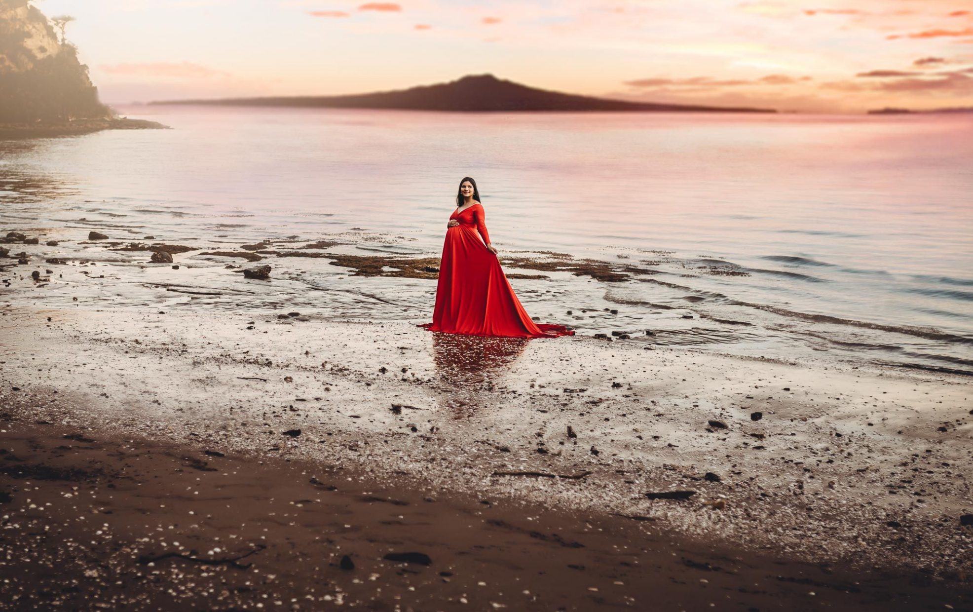 pregnant lady in red dress on beach - Maternity photoshoots Auckland - amber Farooq