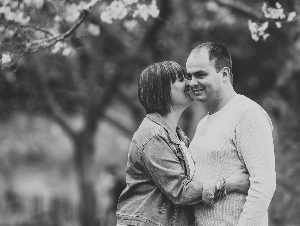 wife with husband smiling Auckland family photography session at Cornwall Park - Milestone Photography sessions