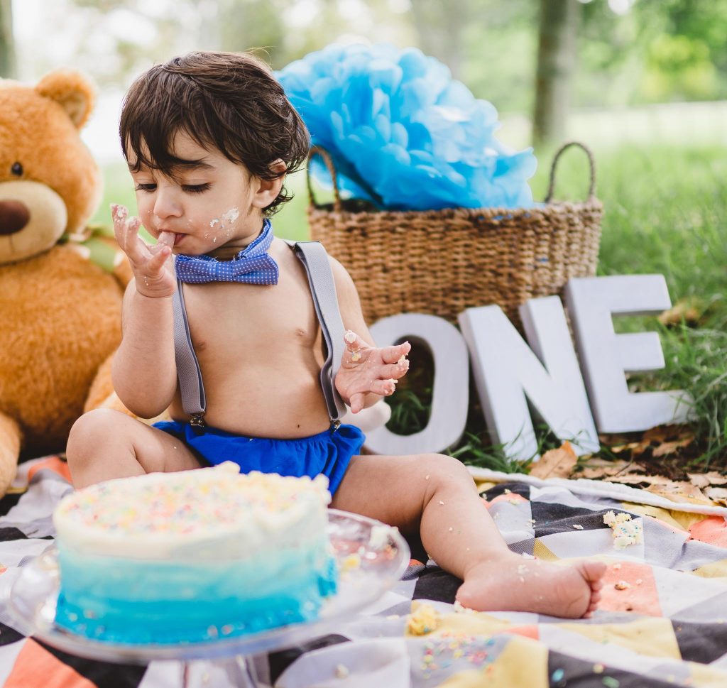 boy eating cake Auckland Cake Smash photo session at Cornwall park - Milestone Photography