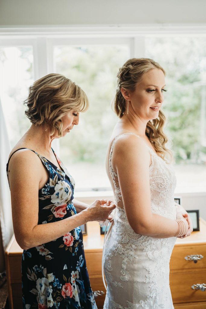 mom setting up bride dress in Auckland - Amber Farooq Wedding Photographer