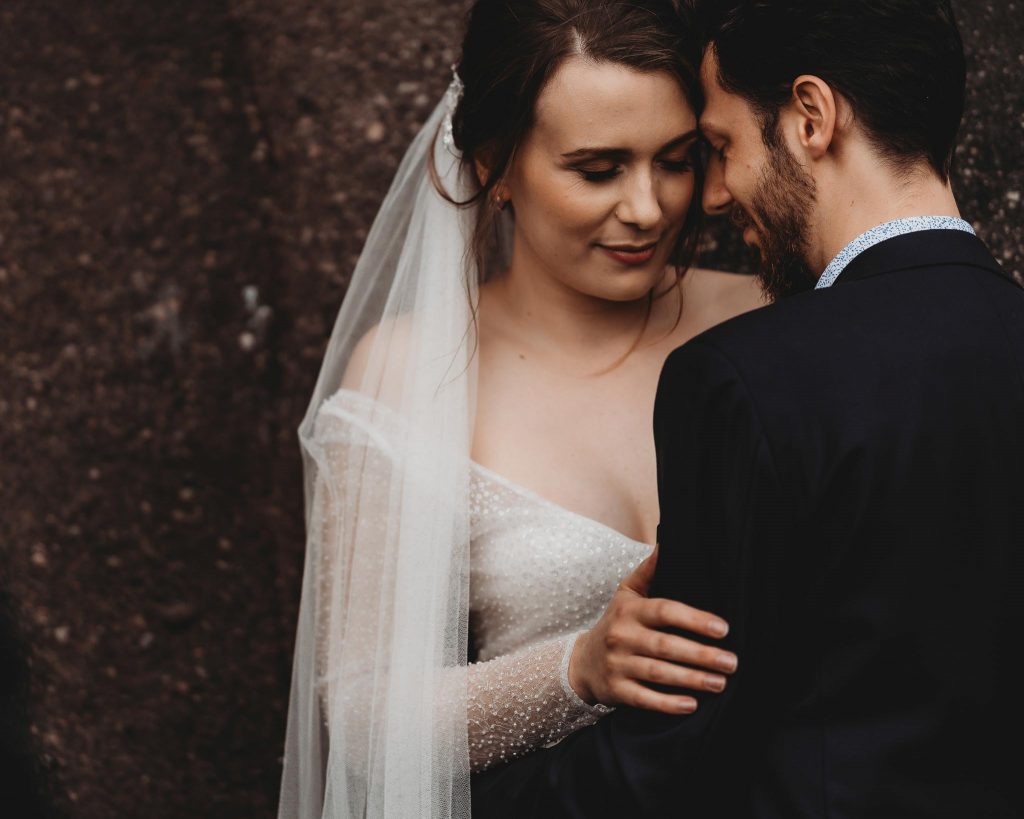 bride with closed eyes hugging groom - Auckland Wedding Photographer