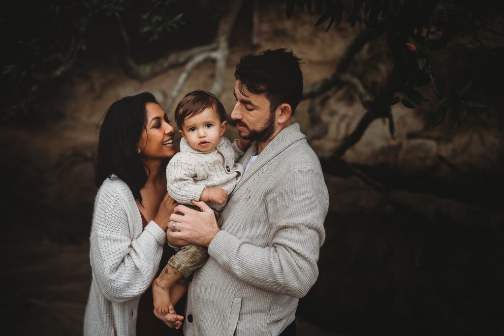 parents looking at one year old boy