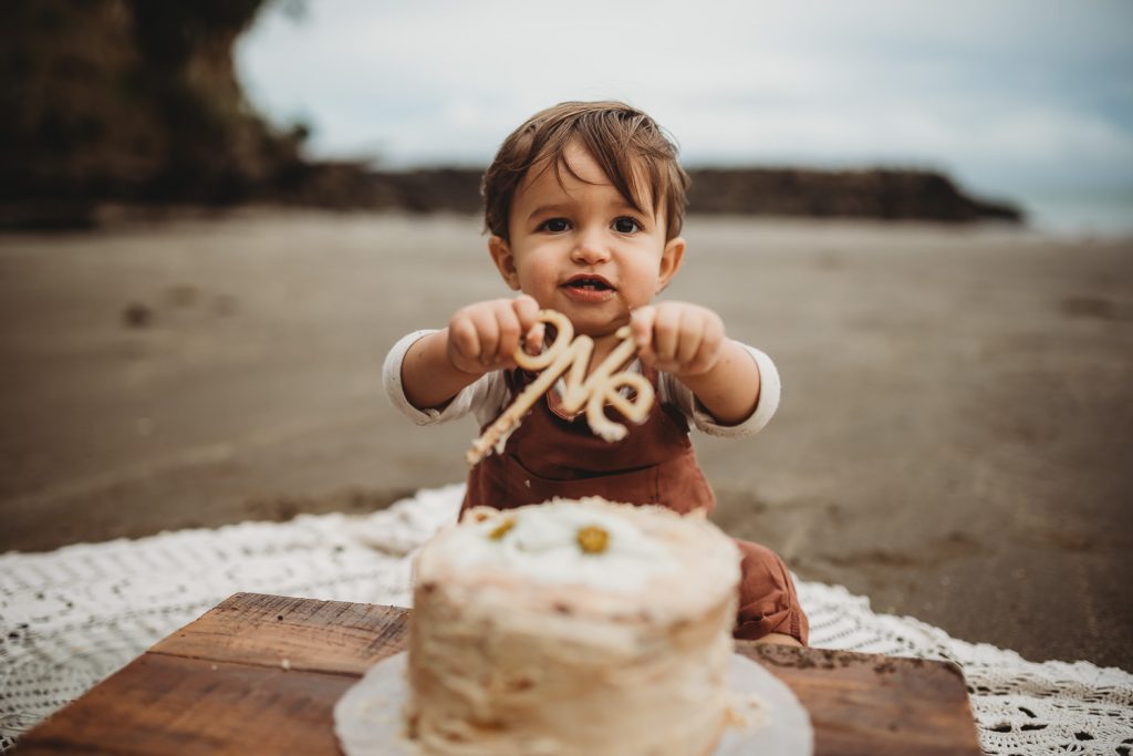 one year old boy holding one's sign
