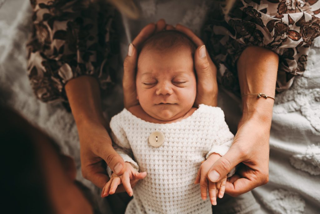 baby boy holding father's hands