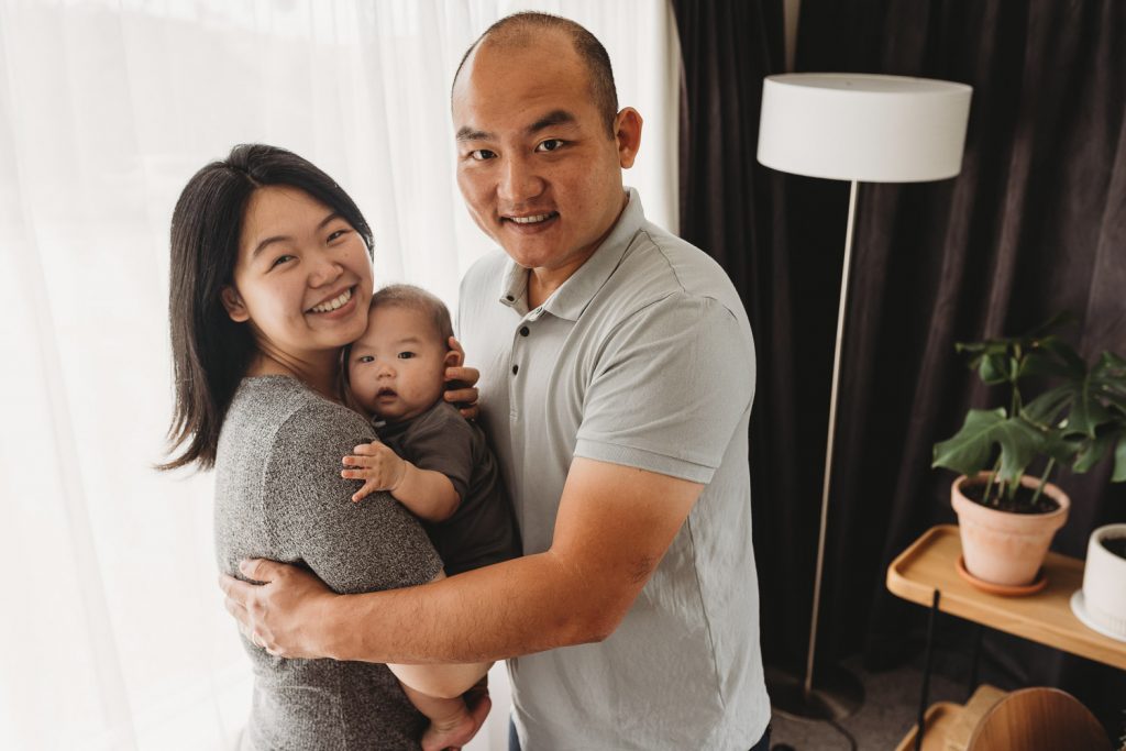 mother father and newborn looking into the camera - Auckland Lifestyle Newborn Photographer Amber Farooq
