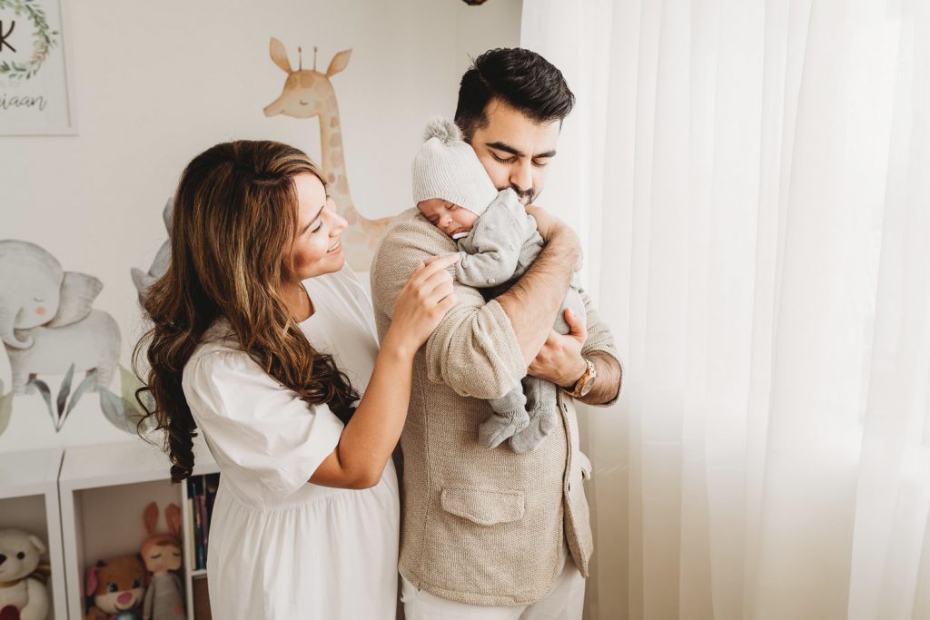 father holding newborn mother looking at him - Auckland Lifestyle Newborn Photographer