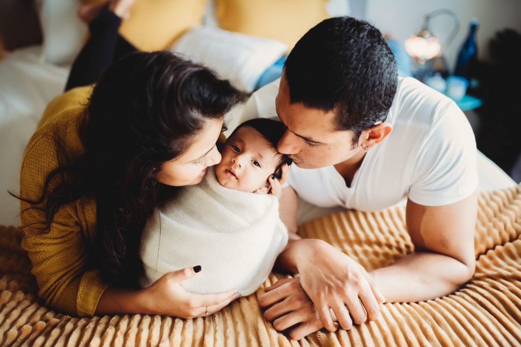 mother father newborn lying on bed - Auckland Photography Amber Farooq