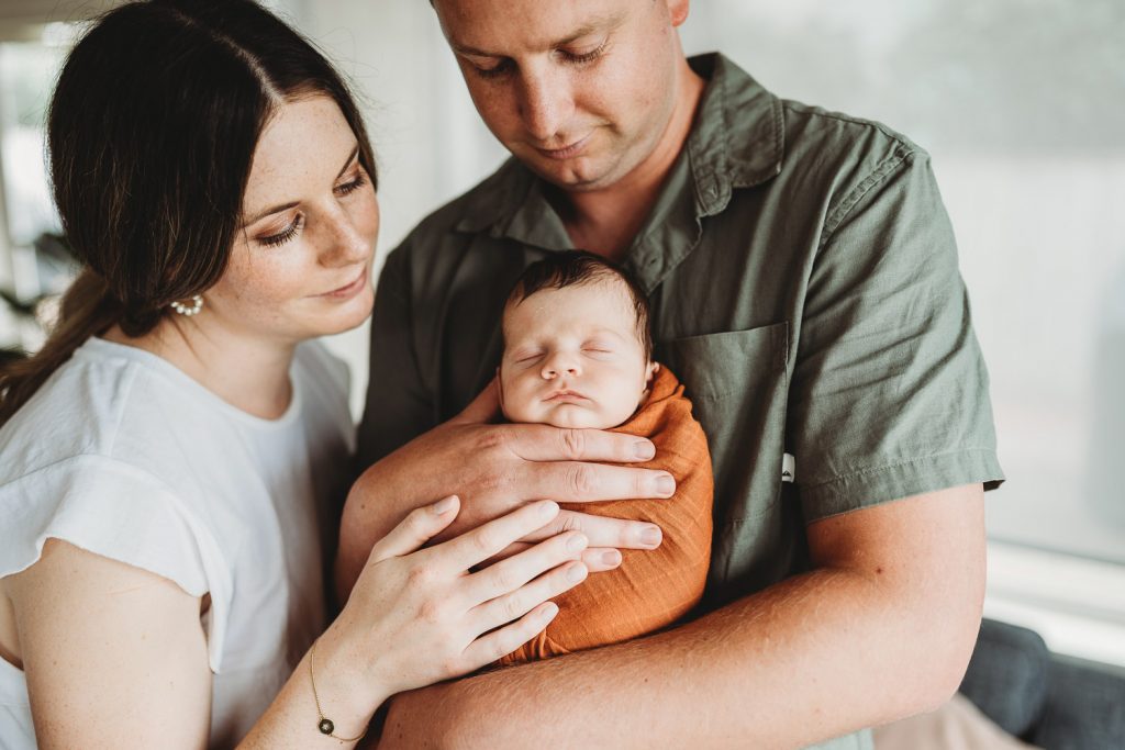 mother father looking at newborn - Auckland Lifestyle Newborn Photographer Amber Farooq
