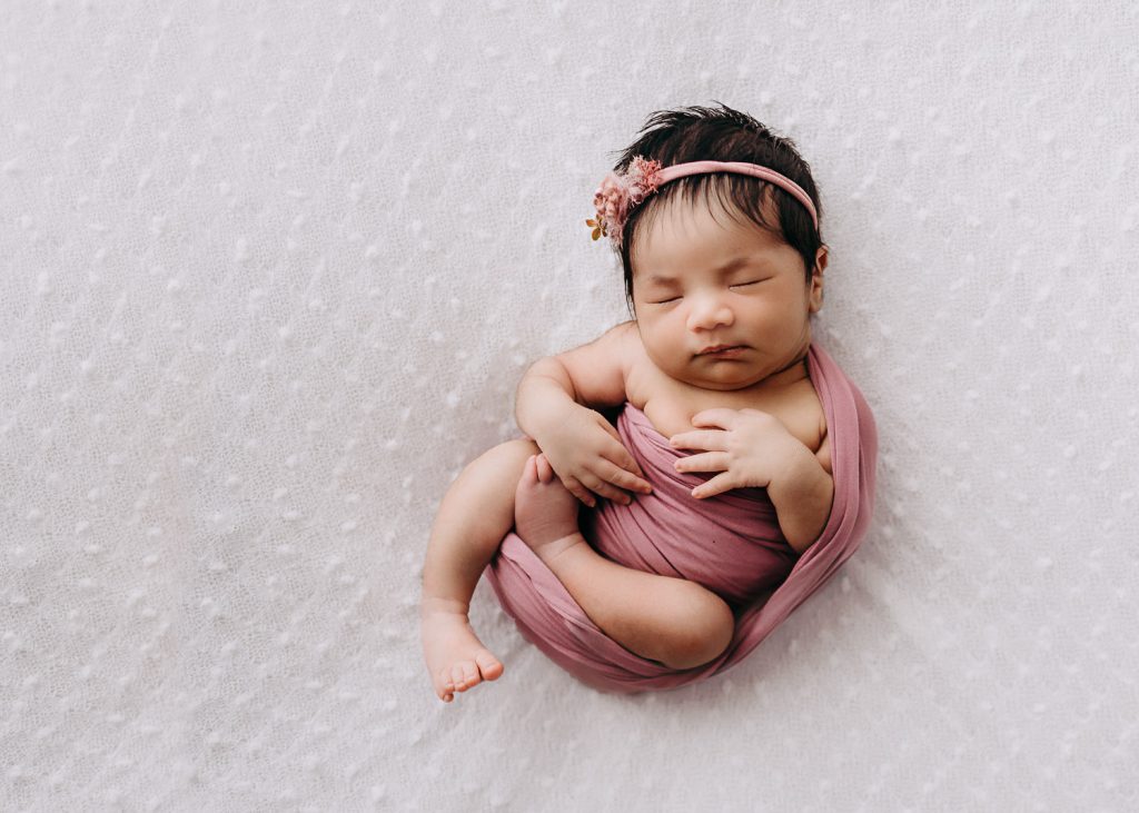 Newborn sleeping swaddled in pink cloth –Auckland Studio Newborn Photography