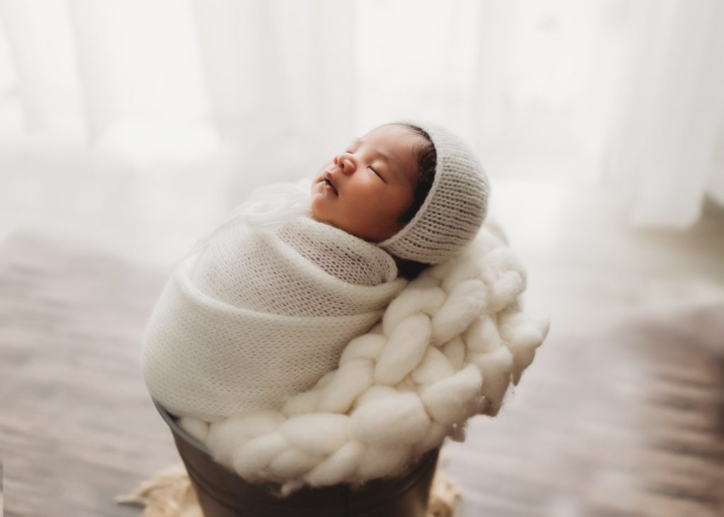 cute newborn in white dress – Auckland studio newborn photographer