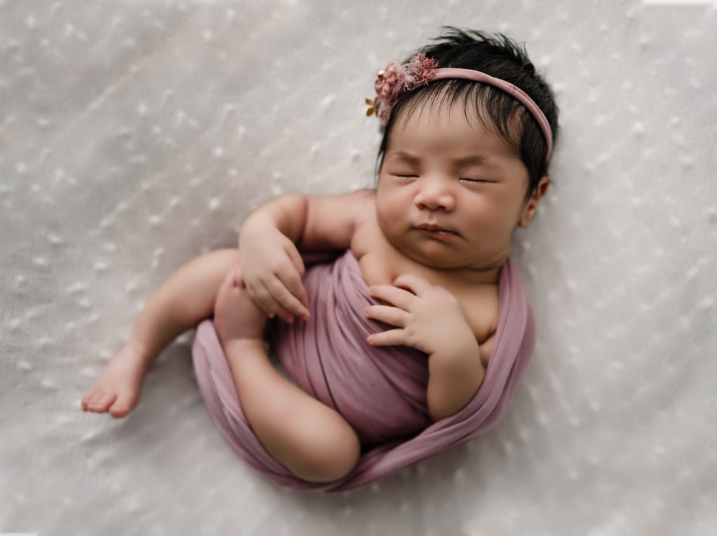 newborn girl in pink cloud wrap– Auckland studio newborn photographer