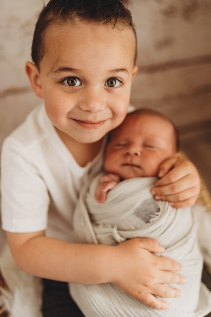 brother holding newborn – Auckland studio newborn photographer