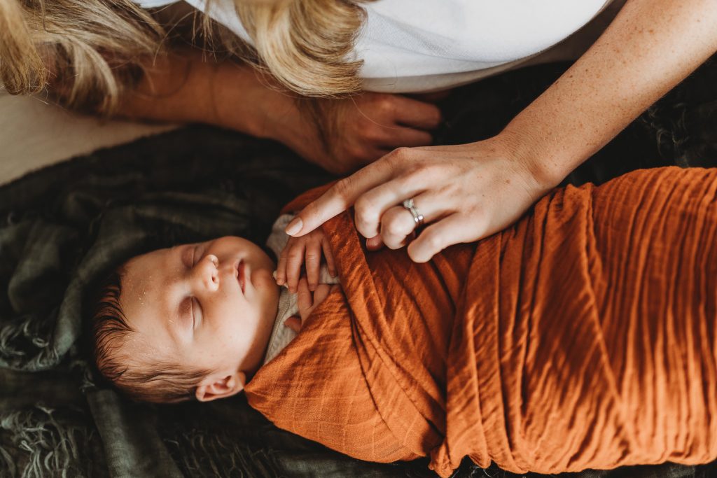 mother holding infant hand