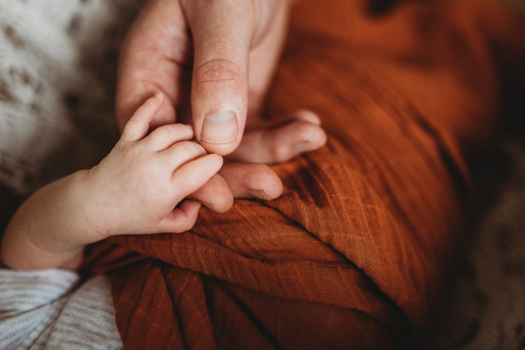father holding newborn hand