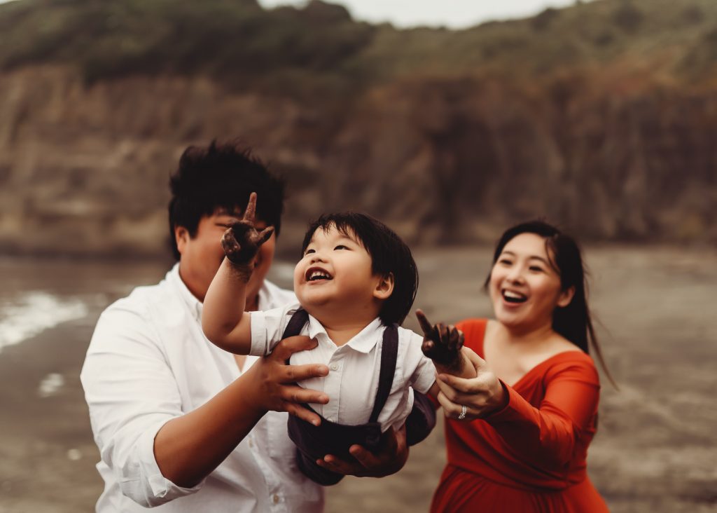 pregnant women with son in his arms during maternity photography in auckland