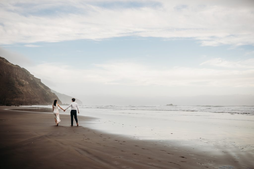 Lishan, a radiant bride, celebrates her honeymoon with a romantic photoshoot at Muriwai Beach.