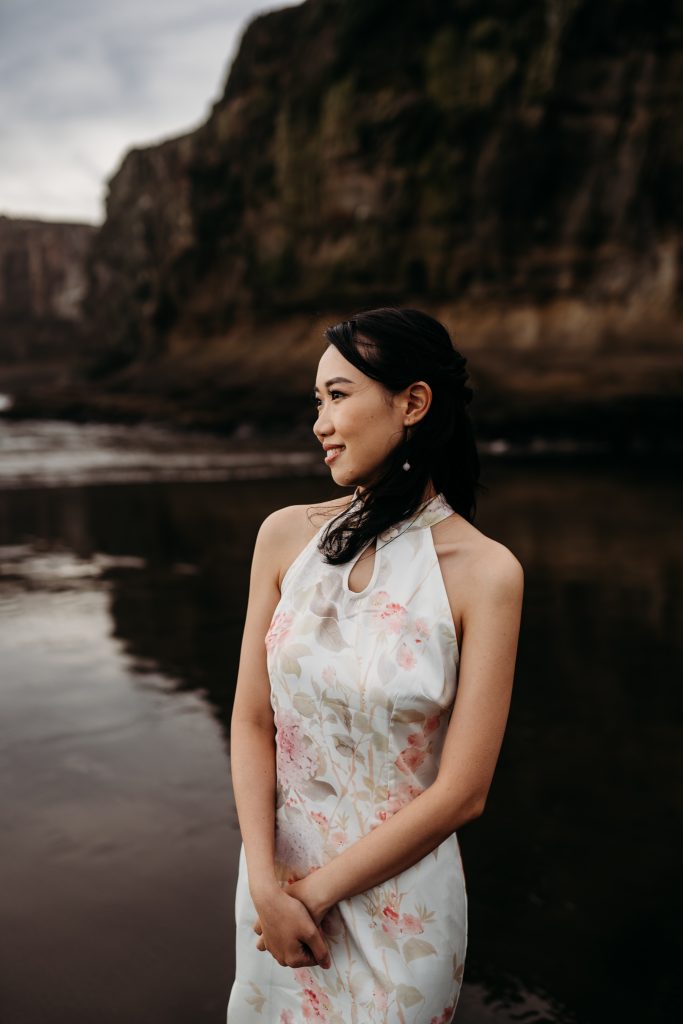 Lishan and Ernest, lost in each other's eyes, embrace the beauty of their honeymoon at Muriwai Beach.