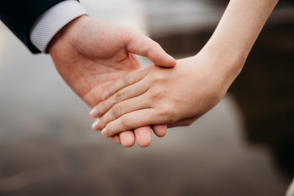 Dramatic cliffs and crashing waves create a stunning setting for Lishan and Ernest's Muriwai Beach honeymoon portraits.