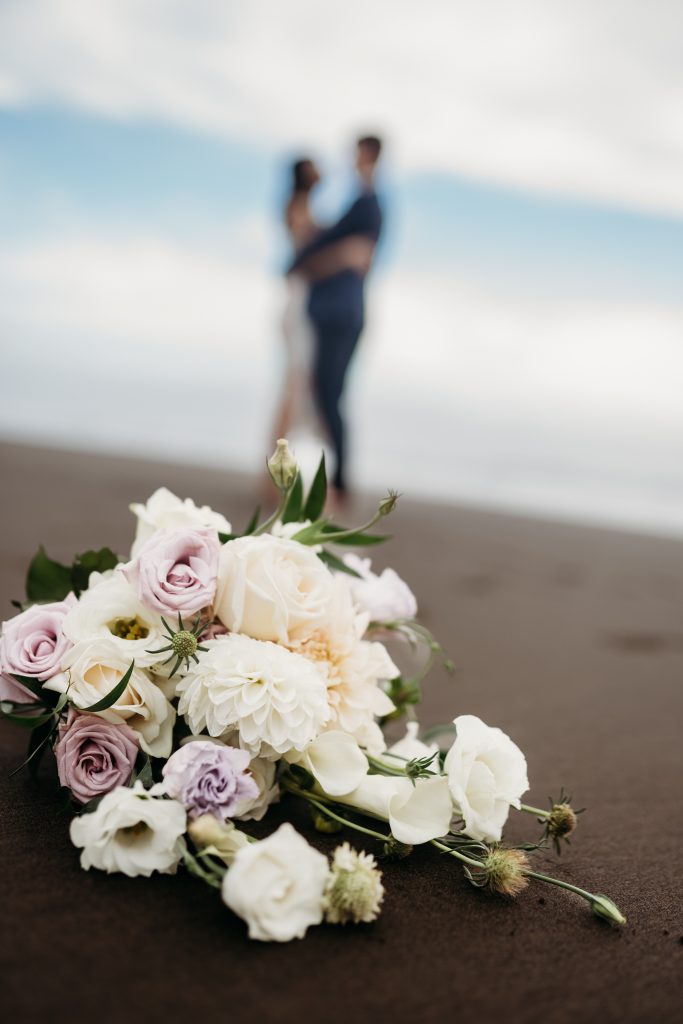Lishan and Ernest, hand-in-hand, stroll along the vast shoreline of Muriwai Beach on their honeymoon.