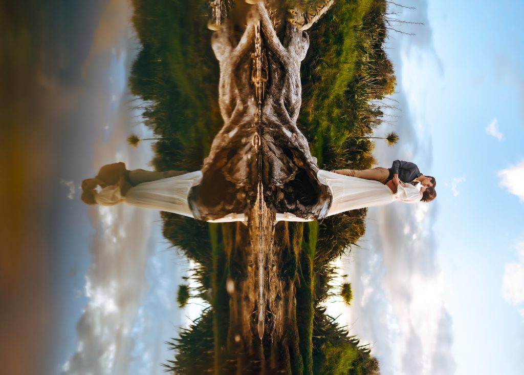 Auckland maternity photo shoot: Mom-to-be laughs with her partner, holding a tiny pair of baby shoes in Auckland.
