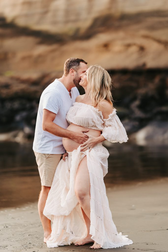 Auckland maternity pictures: Soft focus photo of a pregnant belly with a tiny baby sock resting on it.