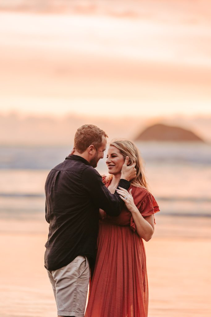 Auckland maternity photography studio: Mom-to-be cradles belly while gazing out the window of a cozy Auckland studio.
