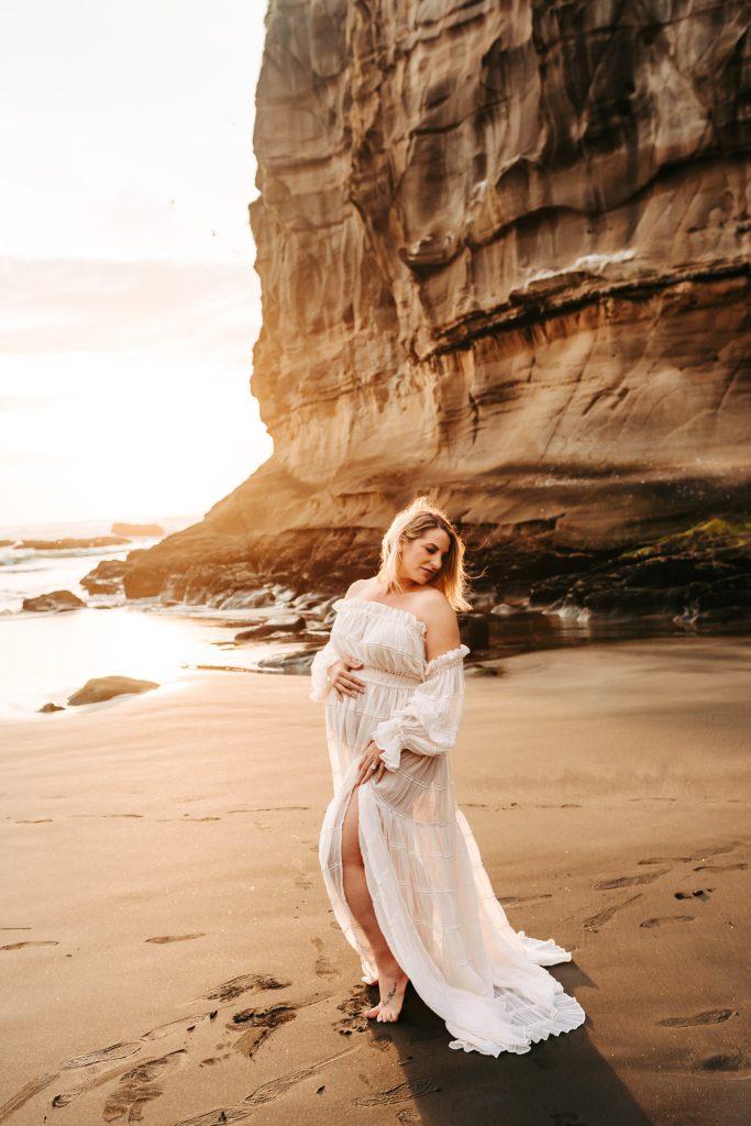 Auckland maternity portraits: A close-up photo of a pregnant belly with tiny hands resting on it.