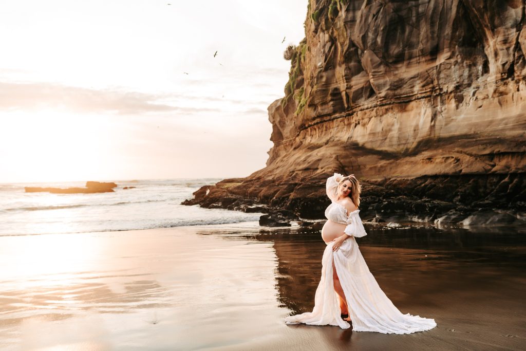 Auckland maternity pictures: Soft focus photo of a pregnant woman's hand resting on her baby bump.