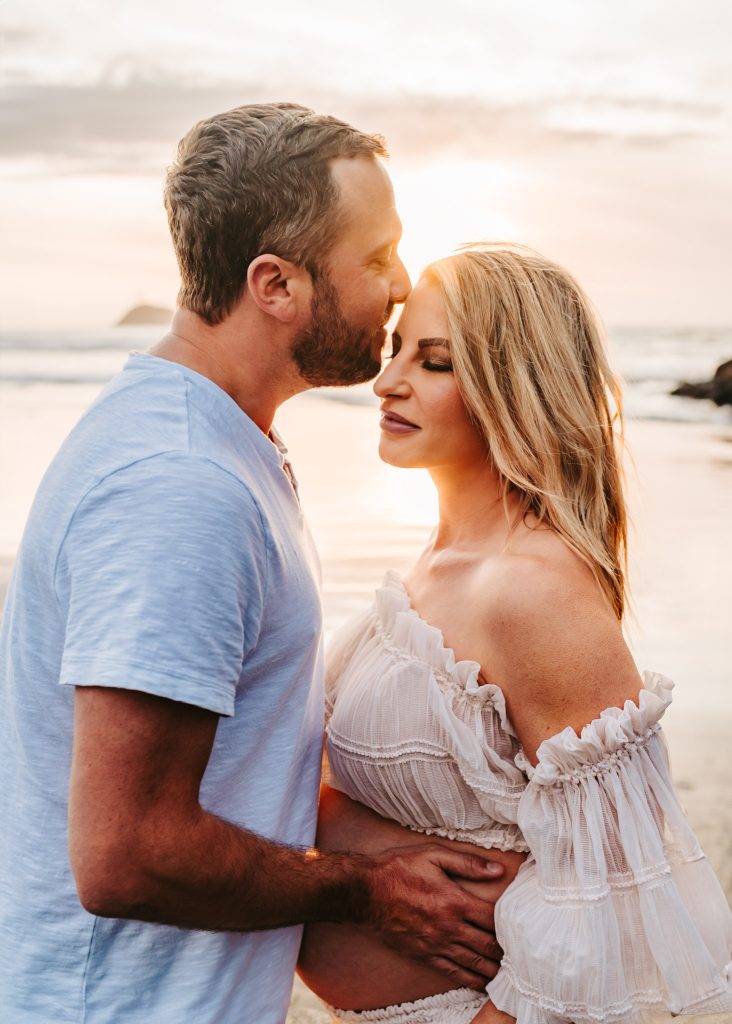 Auckland maternity photography studio: Mom-to-be cradles belly in a cozy Auckland studio setting.