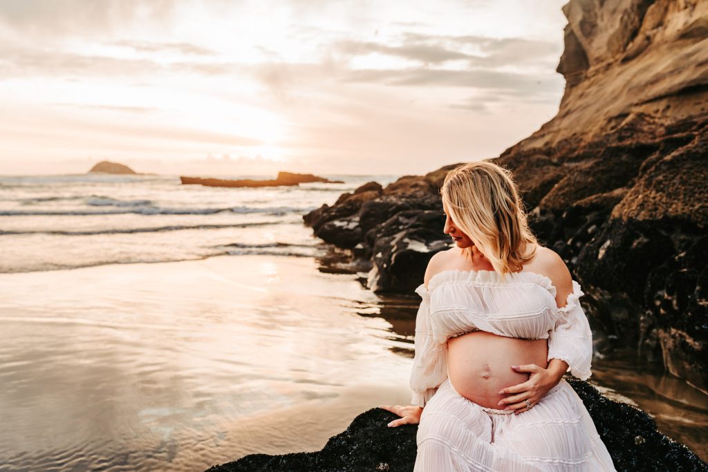 Auckland maternity shoot: Black and white photo of a pregnant belly with tiny footprints painted on it.