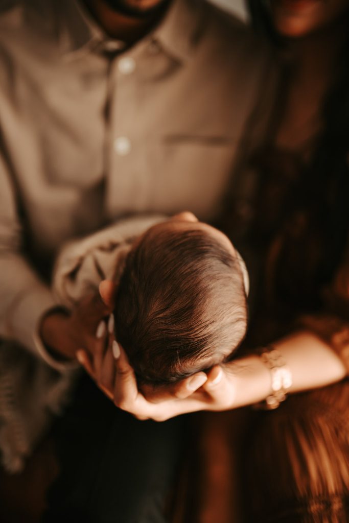 Capturing the early days of parenthood: A loving couple cradles their newborn son Arham in a lifestyle session.