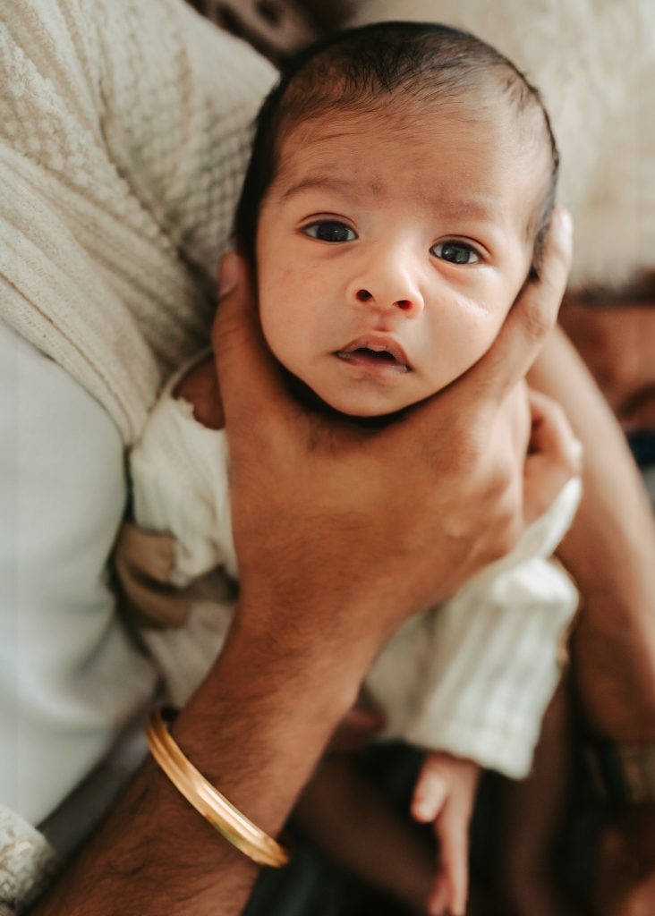 Baby Niam, wrapped in a neutral-toned blanket, poses effortlessly in a dreamy Auckland studio session.