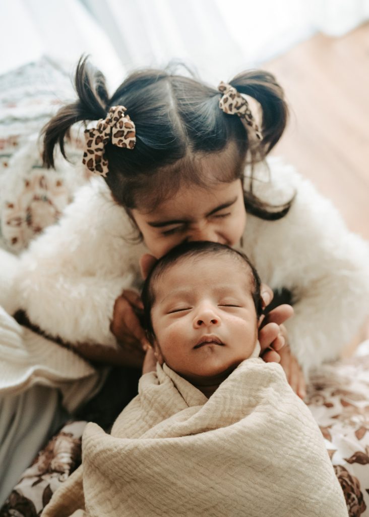 Capturing the wonder of a newborn: Warm studio lights illuminate baby Niam in a timeless portrait.