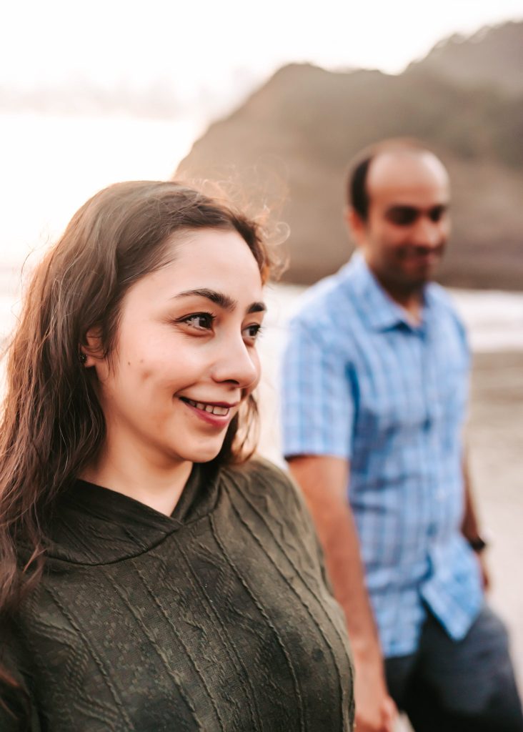 Bethells Beach anniversary photography: Mas dips Huda playfully, capturing the lighthearted spirit of their love story.