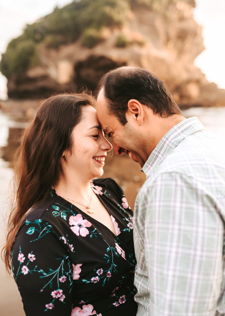 Auckland couple photography: The setting sun casts a warm glow on Mas and Huda during their romantic anniversary shoot at Bethells Beach.